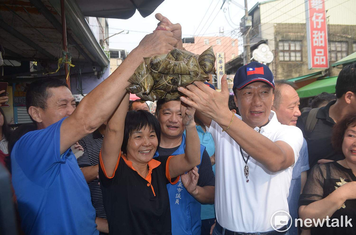 國民黨總統擬參選人郭台銘與民眾一起高舉「花生肉粽」。 圖：蔡坤龍/攝 （資料照片）