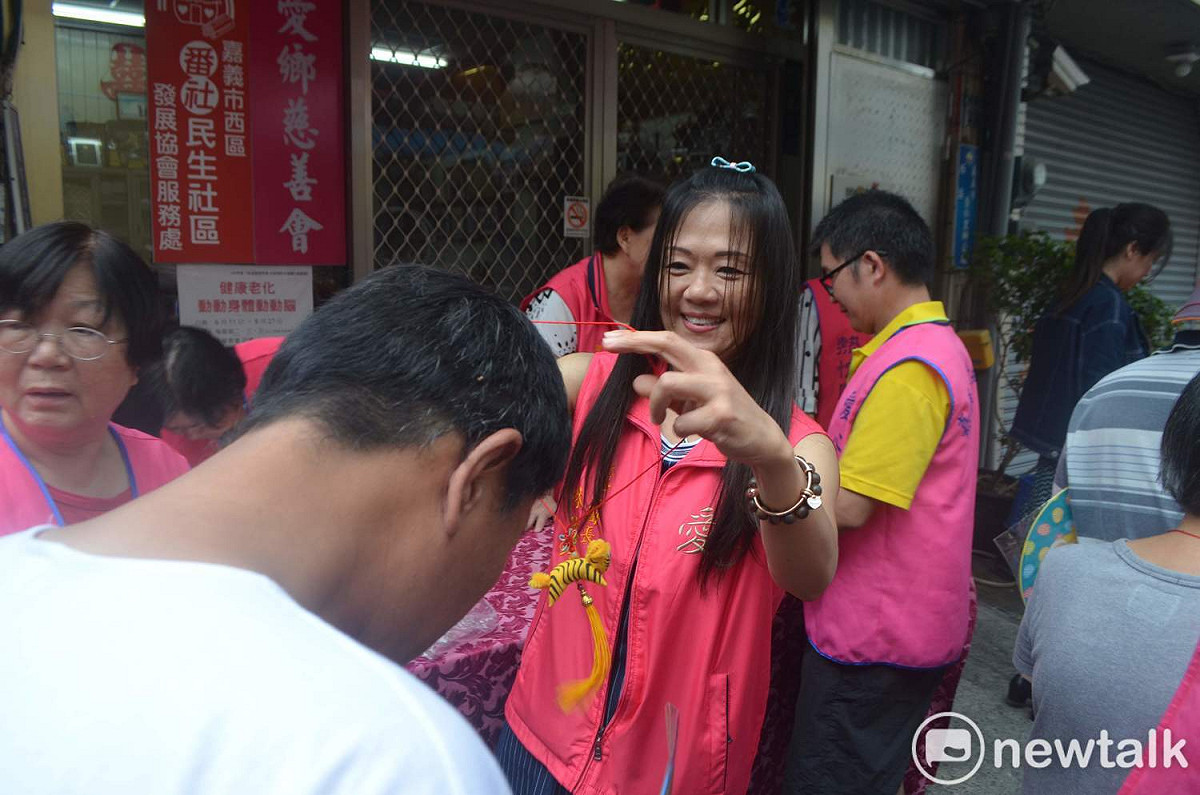 嘉義市愛鄉慈善會今天提前舉辦端午節活動，由理事長陳盈坤的夫人為每一位街友掛上香包。 圖：蔡坤龍/攝