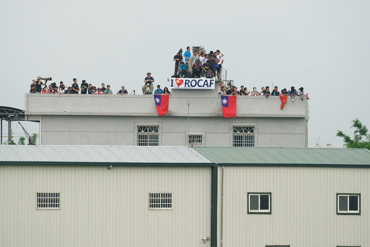 一些民眾在屋頂上掛出中華民國國旗和我愛中華民國空軍的英文布條，向參與戰機起降演練的官兵加油打氣。 圖：張良一/攝