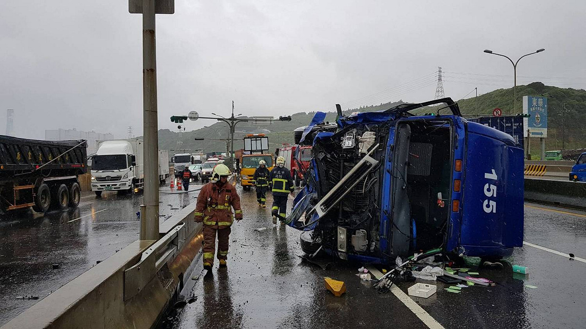 事故現場佔據3個車道，36歲鄭姓駕駛意識清楚，肢體多處擦傷送醫，員警與中壢工務段工程人員冒雨管制交通。 圖：蘆竹分局／提供