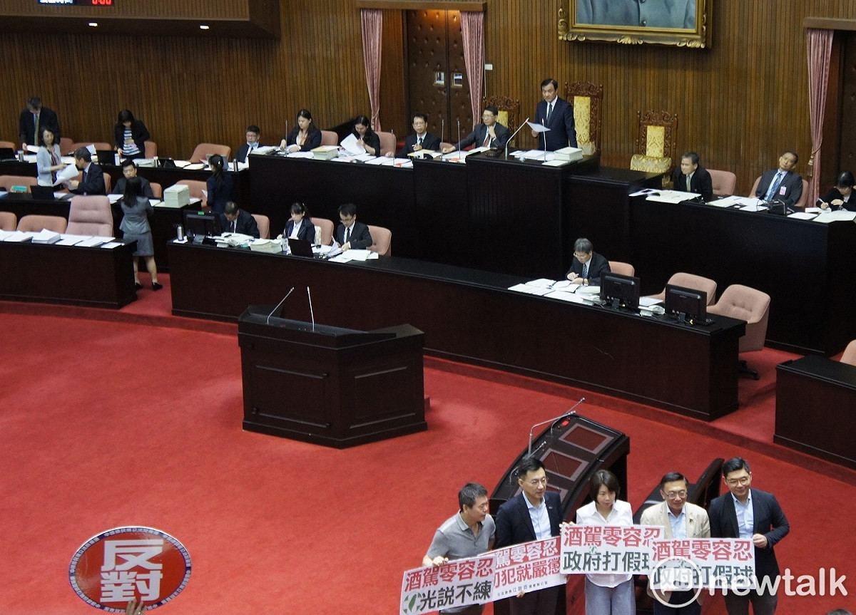 國民黨團不滿修法結果，在立法院長蘇嘉全宣讀三讀結果時，在現場舉牌抗議。 圖:黃建豪/攝