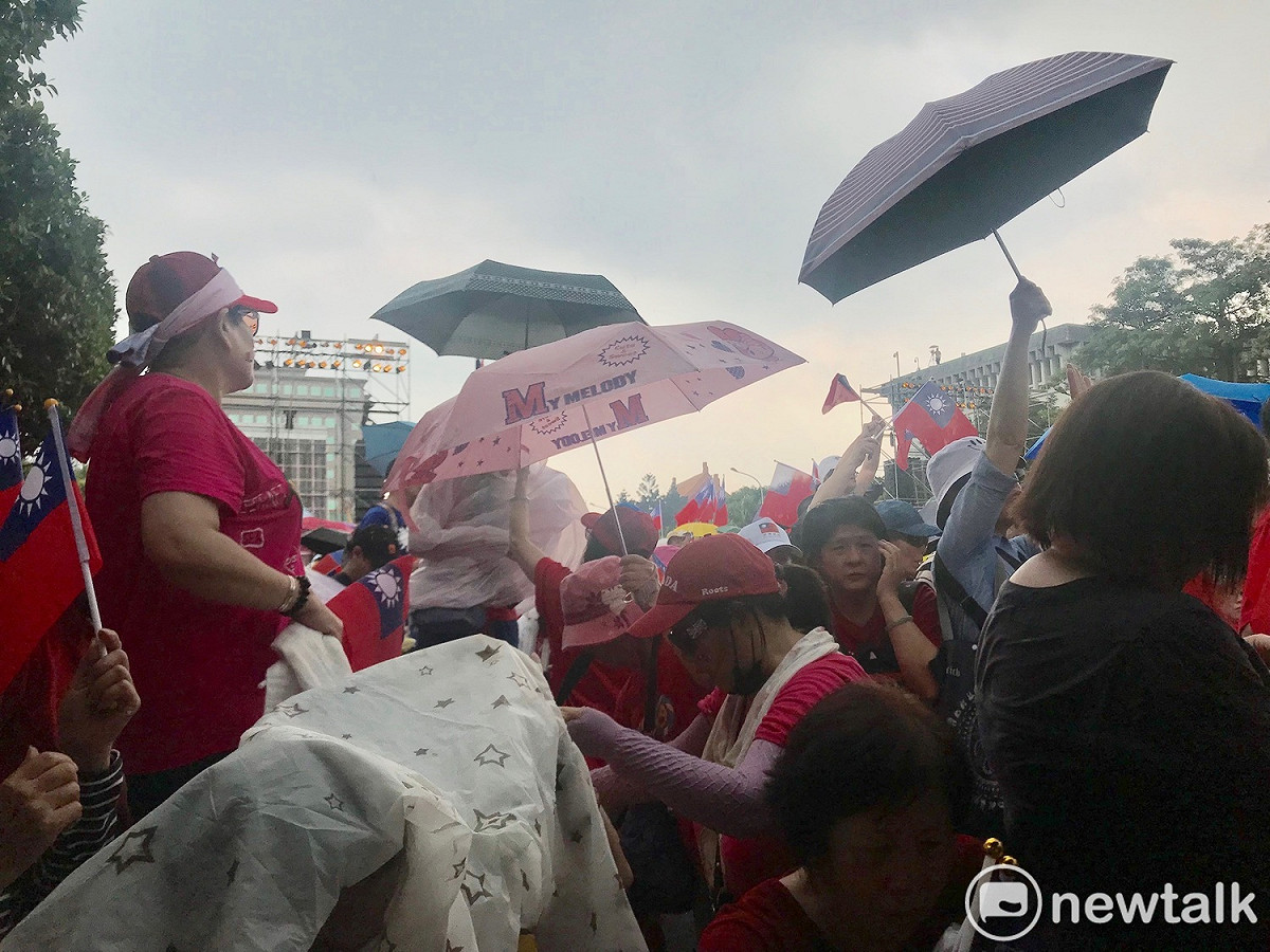 現場下起陣雨，民眾揮舞中華民國國旗振奮信心。 圖：周煊惠 ／攝