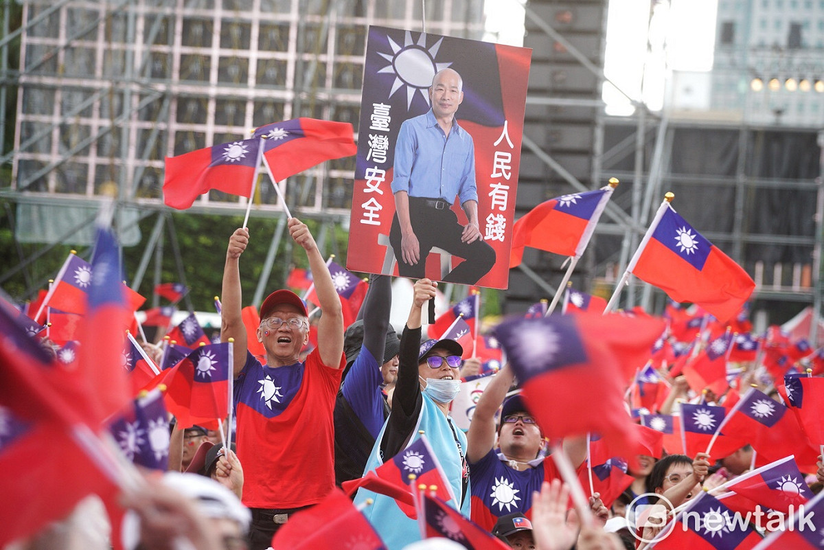 韓粉自製印有韓國瑜照片和「人民有錢、台灣安全」看板，揮舞吶喊。 圖：張良一 / 攝(資料照片)