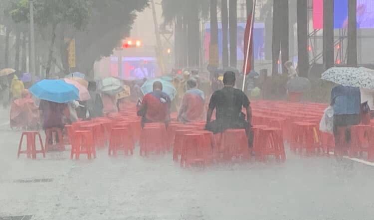 即使下起滂沱大雨，支持者仍忠心的坐在位子上，沒有雨傘也無妨，就是要在現場跟眾人一同支持韓國瑜。 圖：取自黃敬平臉書