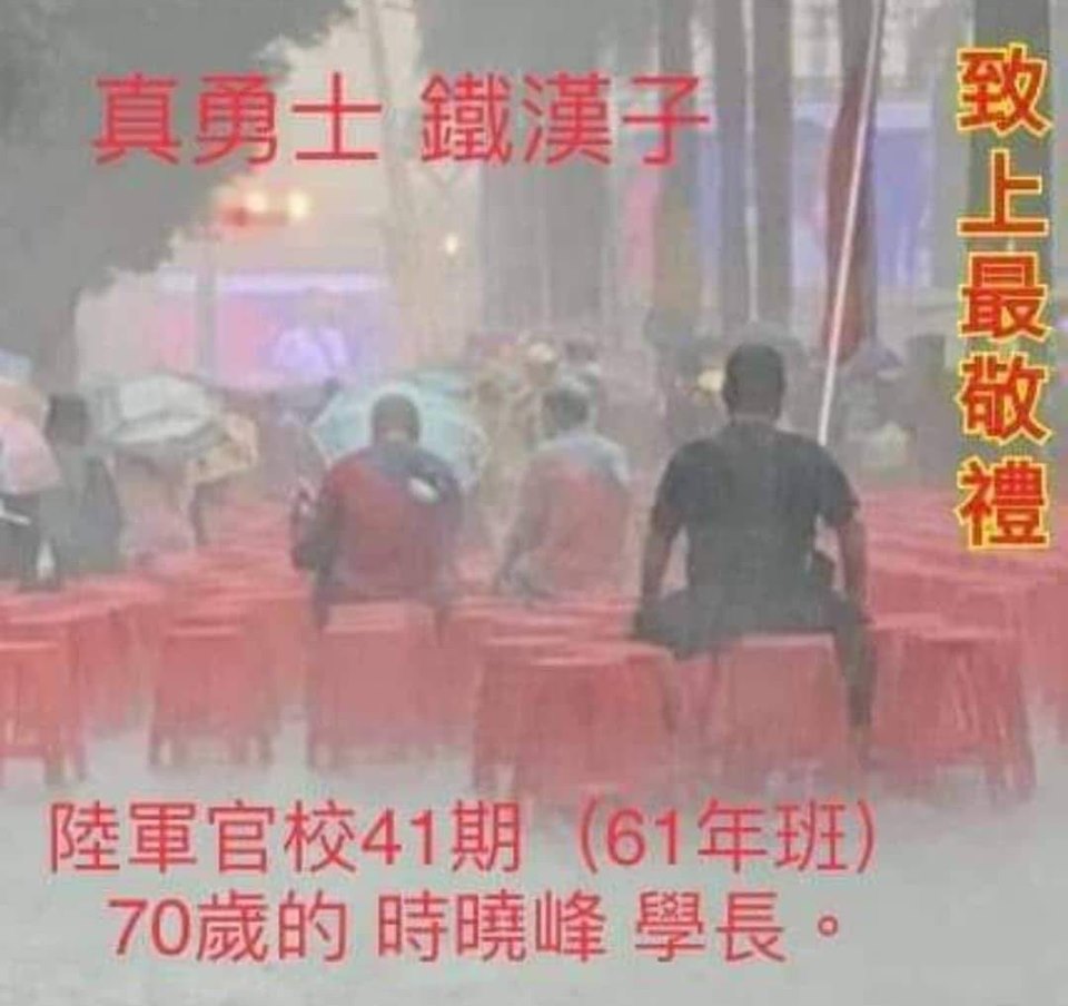 據傳，1日在暴雨中舉著巨大國旗「原地就坐」的「背影哥」，是陸軍官校正期班41期、現年70歲的時曉峰，不過尚未獲得本人證實。 圖：翻攝楊思聖臉書留言區