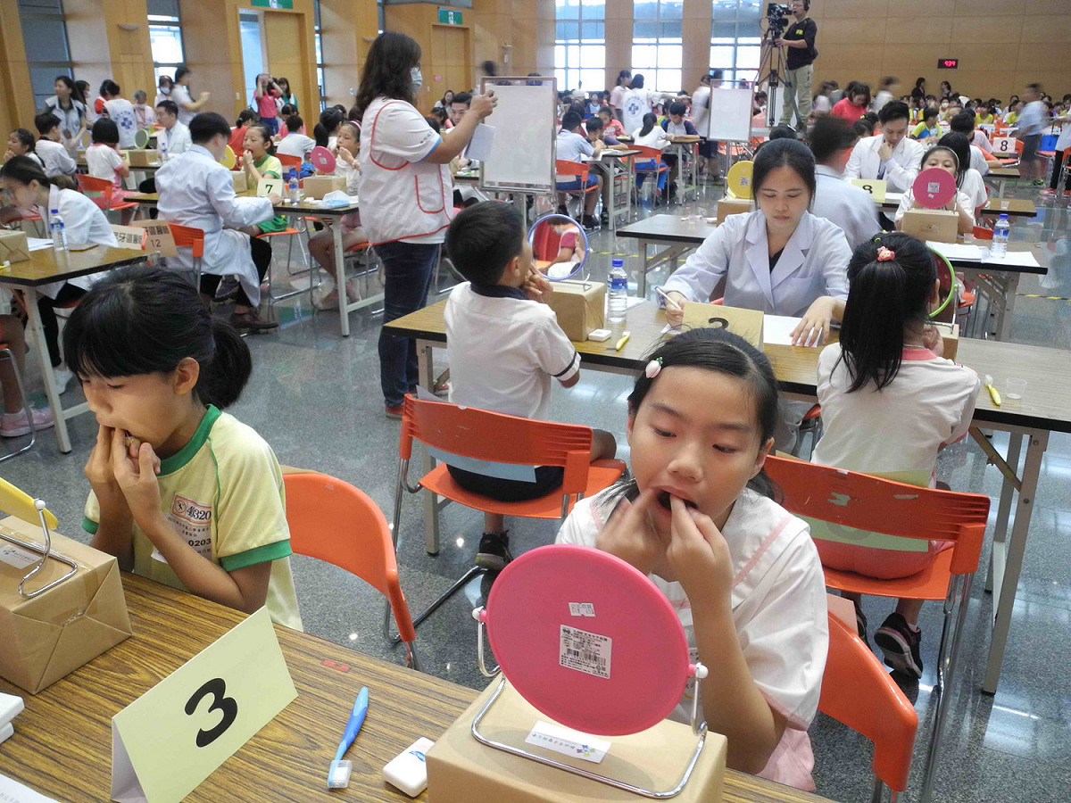 新北市小學潔牙比賽，小朋友當場以牙線、牙刷潔牙，由牙醫師評分。  圖：王峻昌／攝
