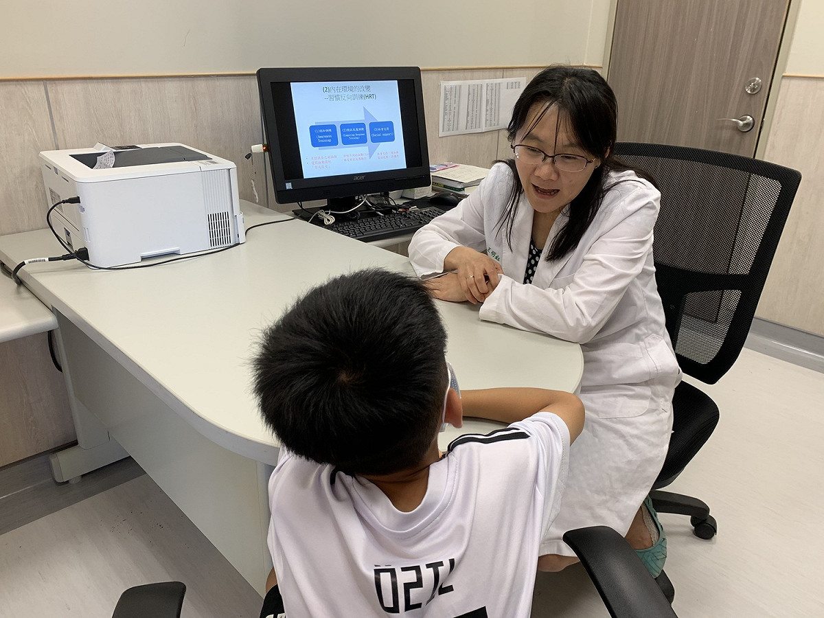 透過身心醫學科主任王明鈺(右)習慣反向訓練，11歲陳小弟弟(左)學會了跟妥瑞氏和平相處。 圖／中醫大新竹附醫提供