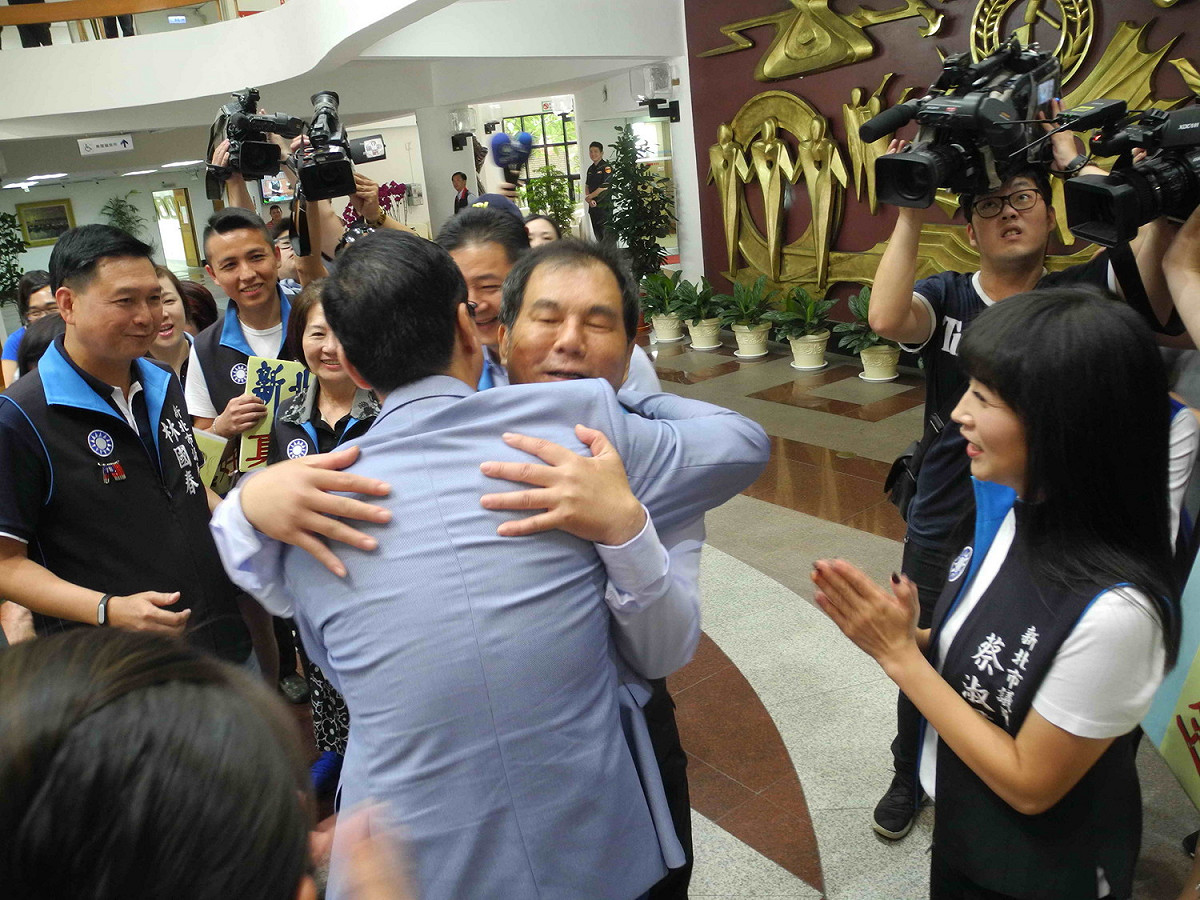 前新北市長朱立倫到新北市議會接受國民黨團為他慶生，與黨團書記長周勝考等人逐一擁抱，議員蔡淑君在旁高喊「前進總統府」。 圖：王峻昌/攝