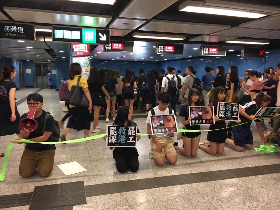 香港志眾成員今（14）日一早於地鐵美孚站集體下跪，呼籲市民相挺總罷工。 圖：翻攝自 潘小濤 臉書粉專