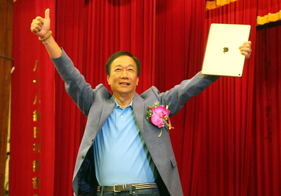 鴻海集團董事長郭台銘15日下午到台南崑山科技大學參加畢業典禮，受到學生熱情歡迎，並在台上高舉雙手向眾人致意。 圖：中央社
