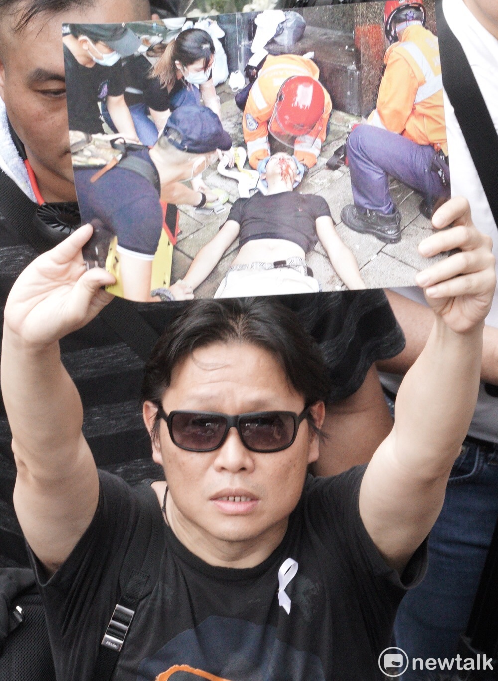 港民拿出示威者遭到香港警方槍擊照片，表達出「追究開槍責任」的訴求。 圖：張良一 / 攝