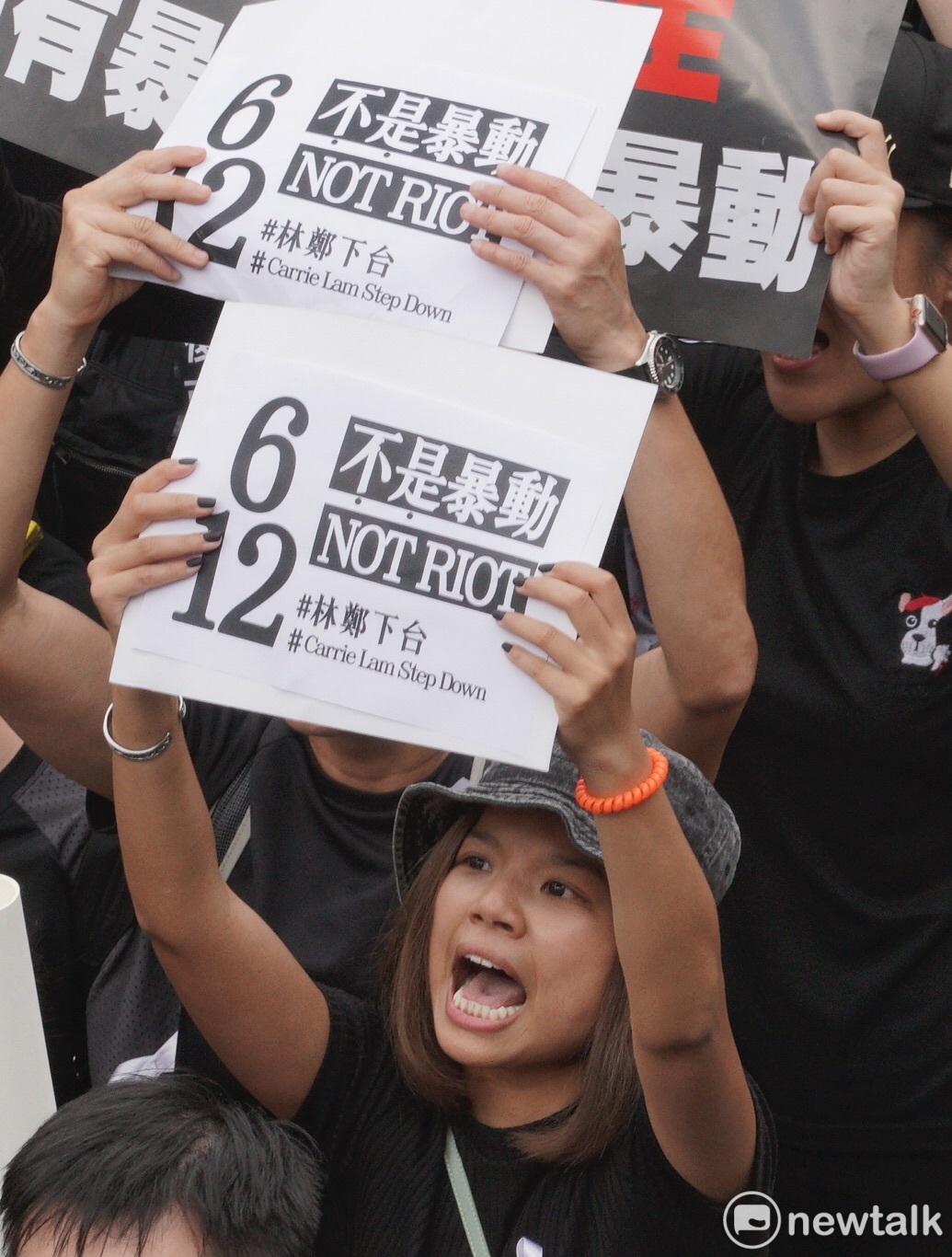香港民眾高舉海報，內容寫著「6/12不是暴動#林鄭下台」。 圖：張良一 / 攝