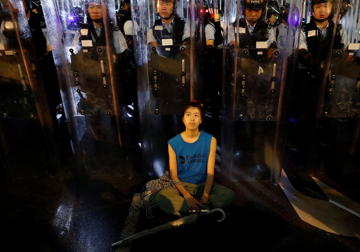 香港民眾連日發起「反送中」示威，抗議逃犯條例進行，在警民衝突與對峙之中，也出現了許多令人印象深刻的畫面，其中，一名在鎮暴警察警盾前冥想靜坐表示抗議的女子，畫面被媒體捕捉下來。 圖：達志影像／路透社
