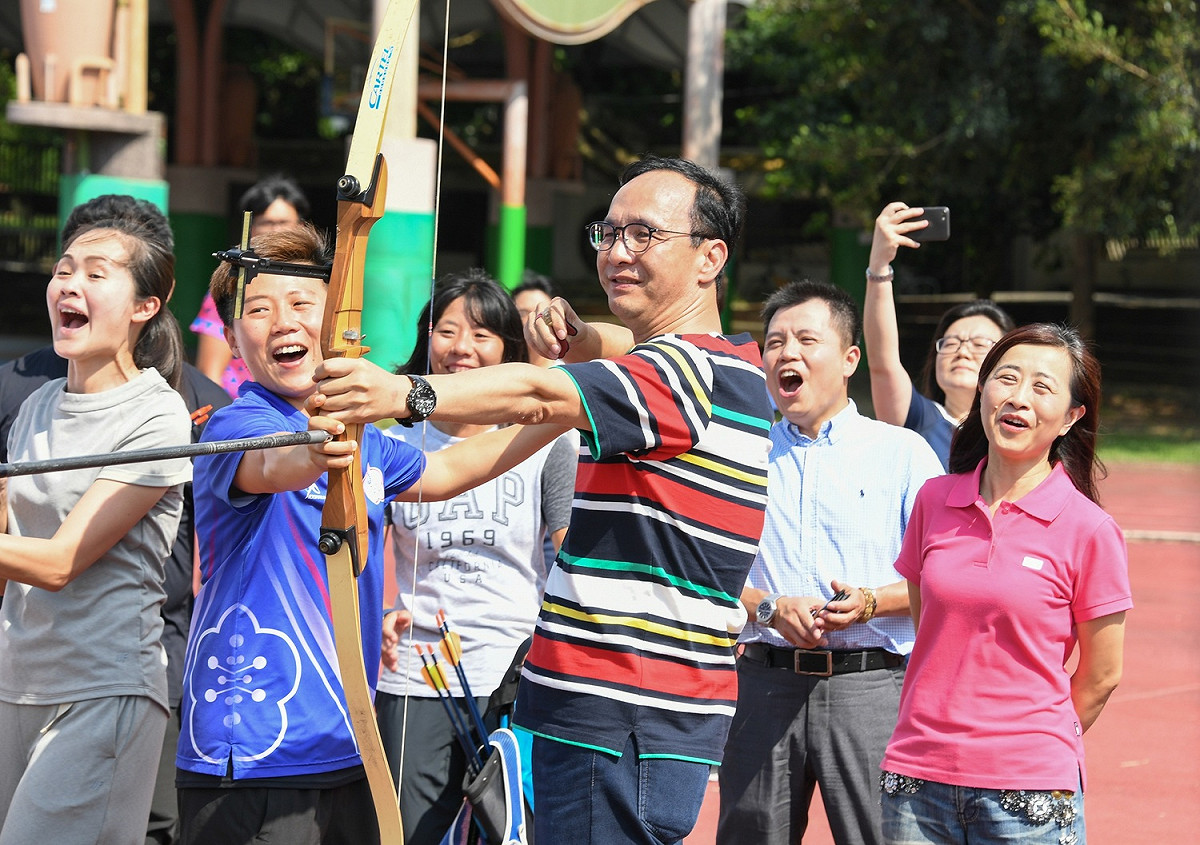 明德高中校友、奧運名將「雷母」雷千瑩（右２藍衣者）教朱立倫拉弓射箭。 圖：朱立倫辦公室／提供