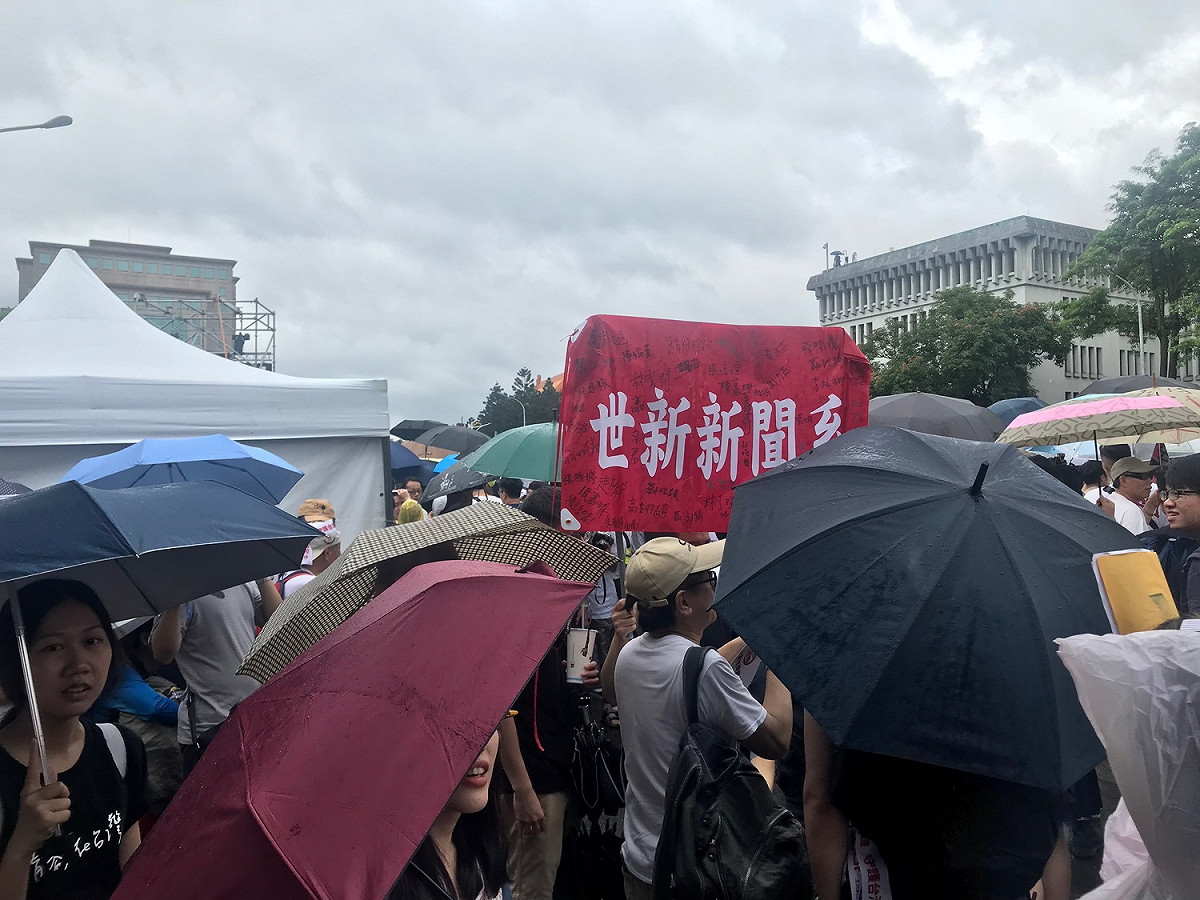 有學生高舉「世新新聞系」布條，支持反紅媒活動。 圖：周煊惠 ／攝