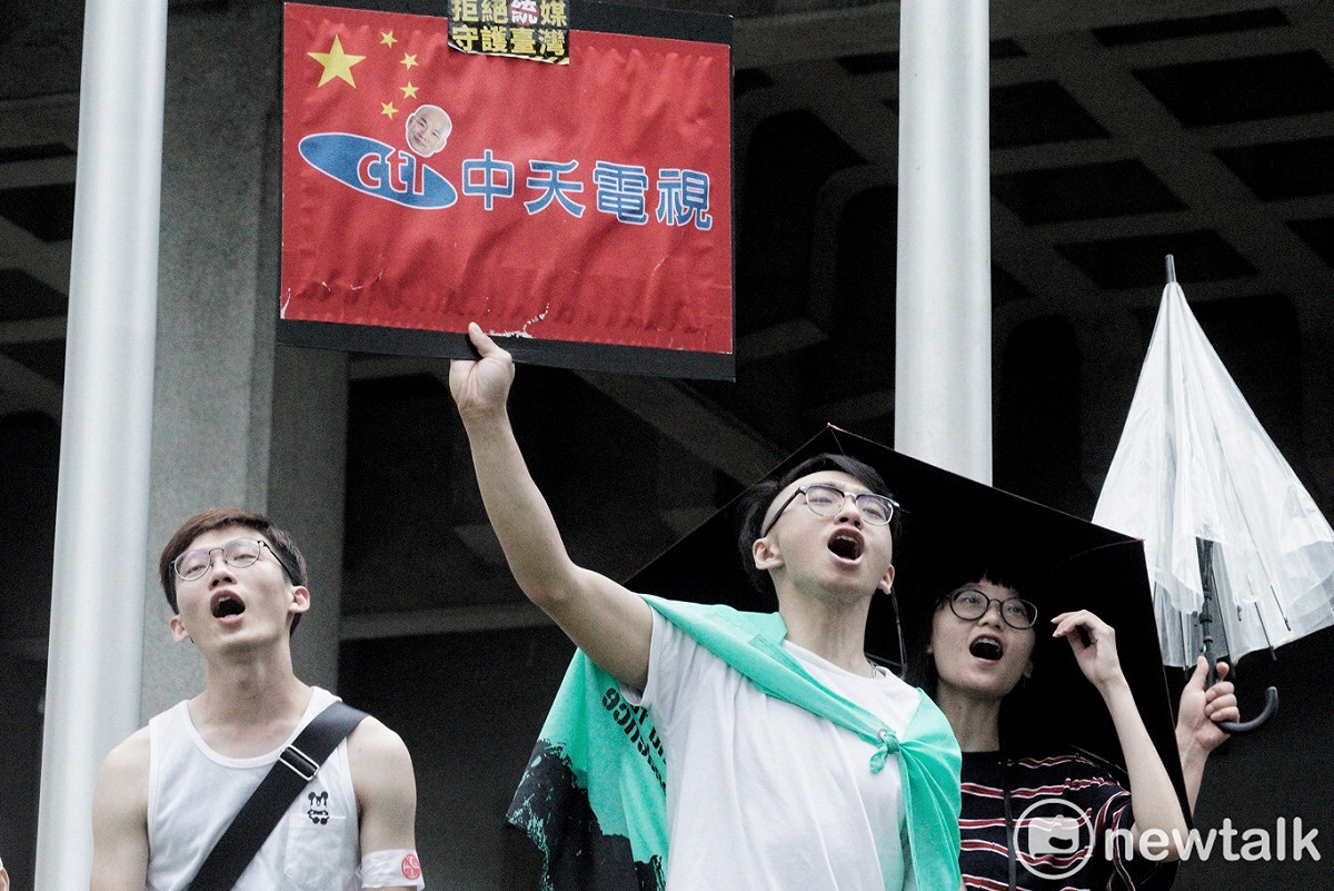 反紅媒遊行，民眾高舉自製的「中夭電視」的牌子，上頭寫著「拒絕統媒，守護台灣」。 圖：張良一 / 攝