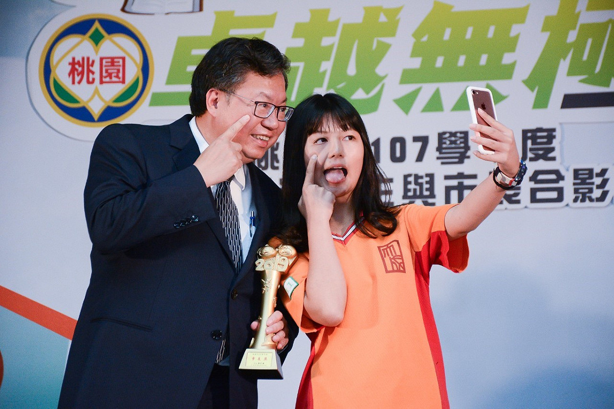 桃園市長鄭文燦與領獎學生合照，對於學生要求擺pose合照都來者不拒。 圖：桃園市政府/提供