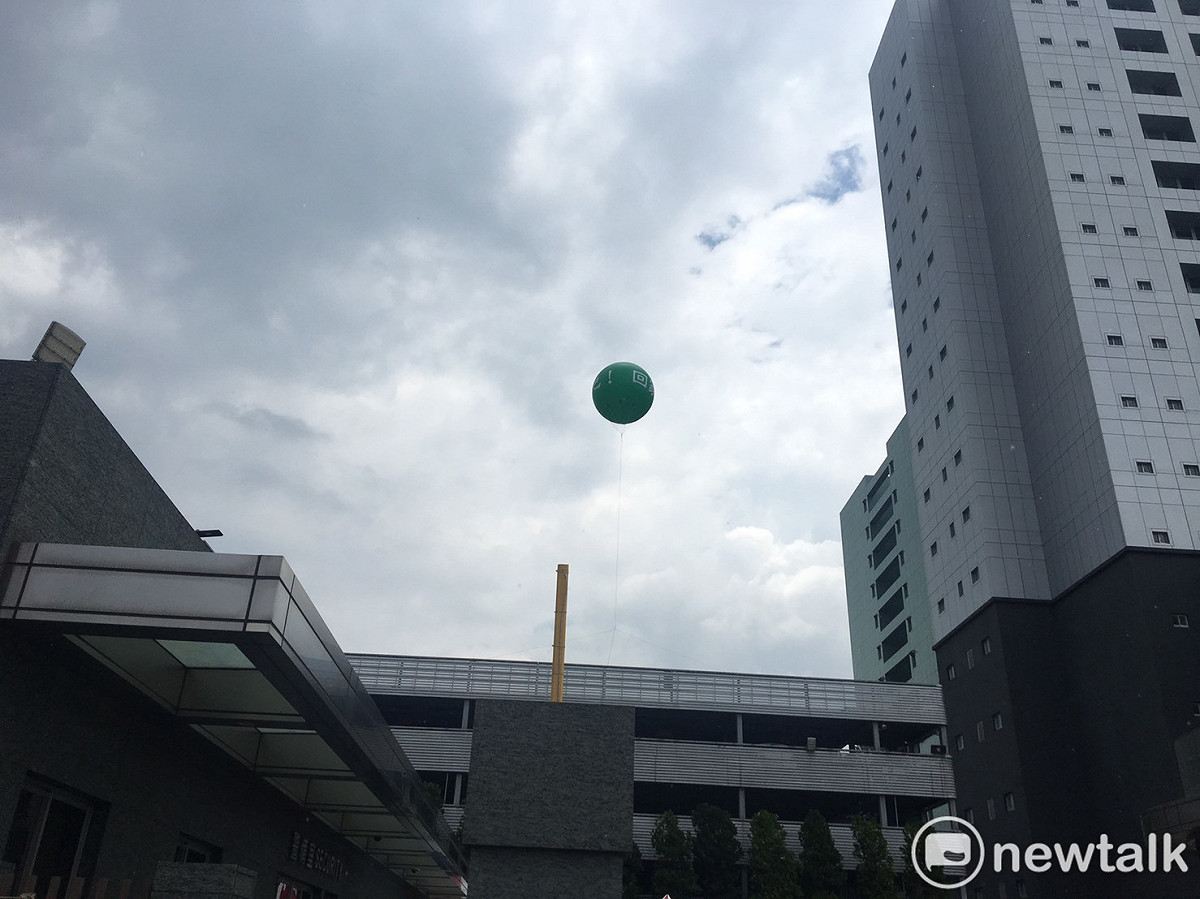 長榮航空公司南崁總部大樓屋頂升起汽球，上頭寫著大大的「回家吧」呼籲在門口集結的罷工會員結束罷工趕快回家。 圖：林昀真/攝
