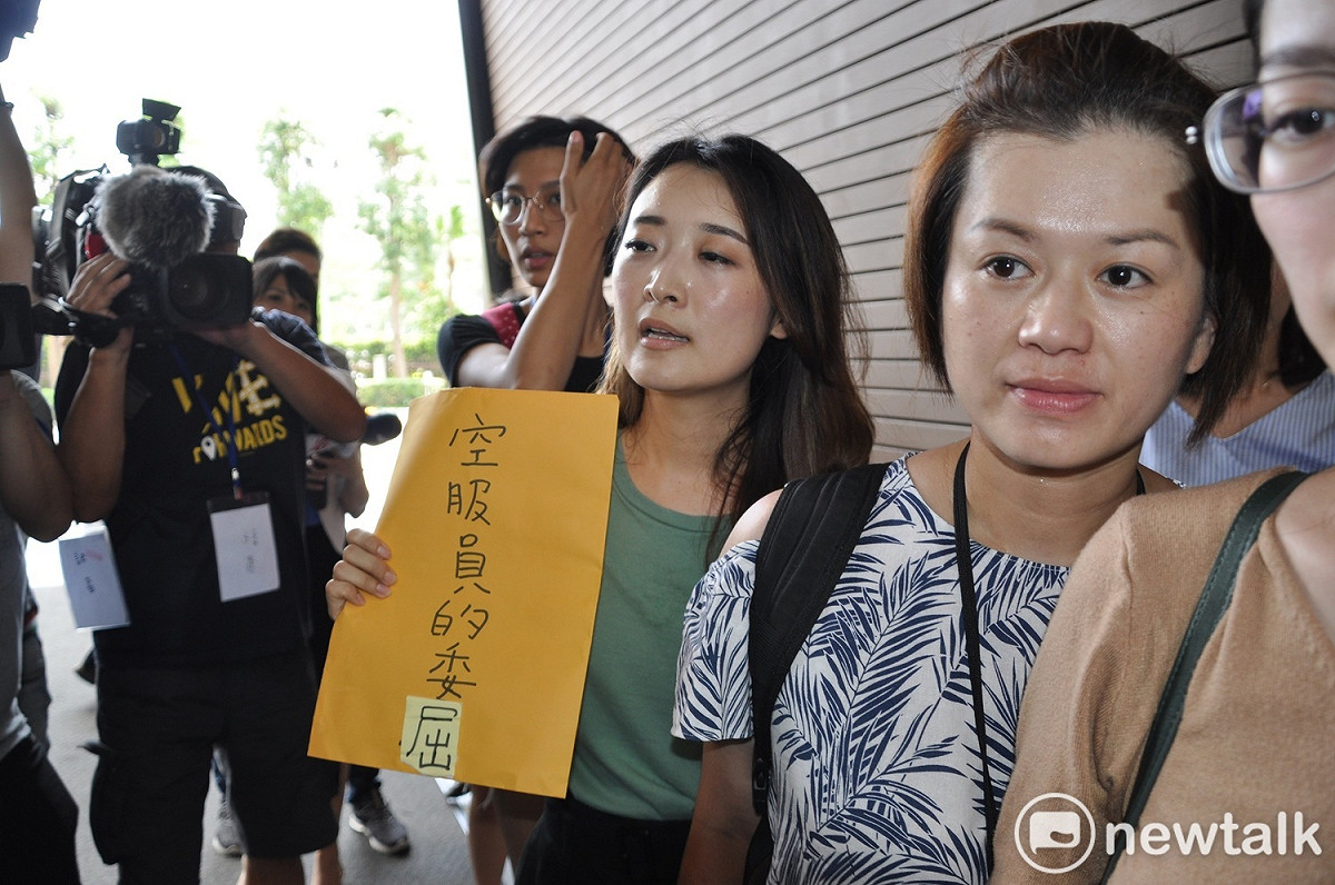 桃園市空服員職業工會由理事廖以勤、工會代表趙婕歡、王美心、李瀅、黃蔓鈴等五位代表手持「空服員的委屈」走進長榮航空南崁總部大樓。 圖：林昀真／攝