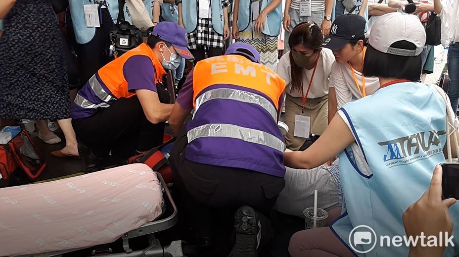 罷工空服員疑似因高溫天候引發不適造成「熱過敏」，突然昏倒，嚇壞在場的罷工人員及媒體。 圖：林昀真/攝