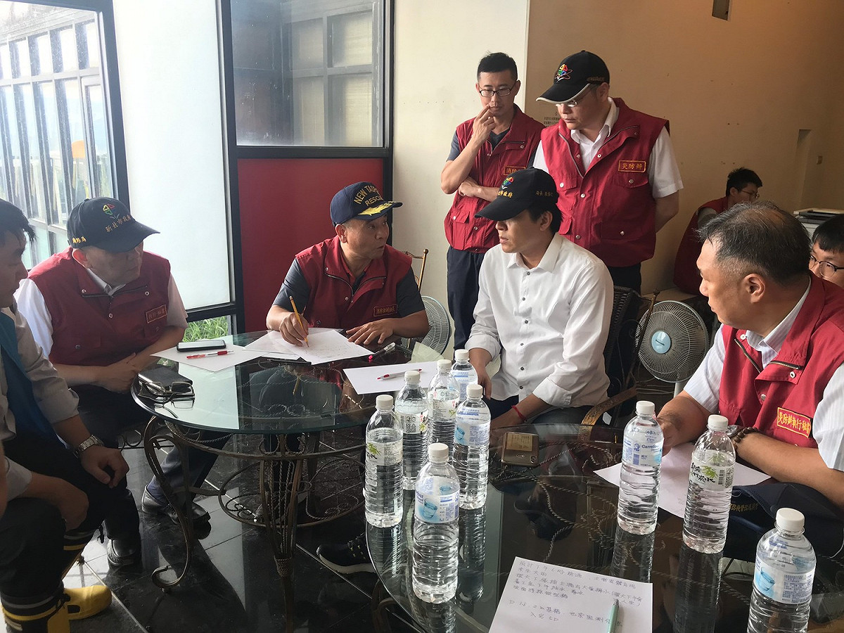 新北市府在汐止區秀山路坍方處成立前進指揮所，消防局長黃德清（左二）、工務局長朱惕之（坐者右二）等都趕到現場指揮。 圖：新北市消防局提供