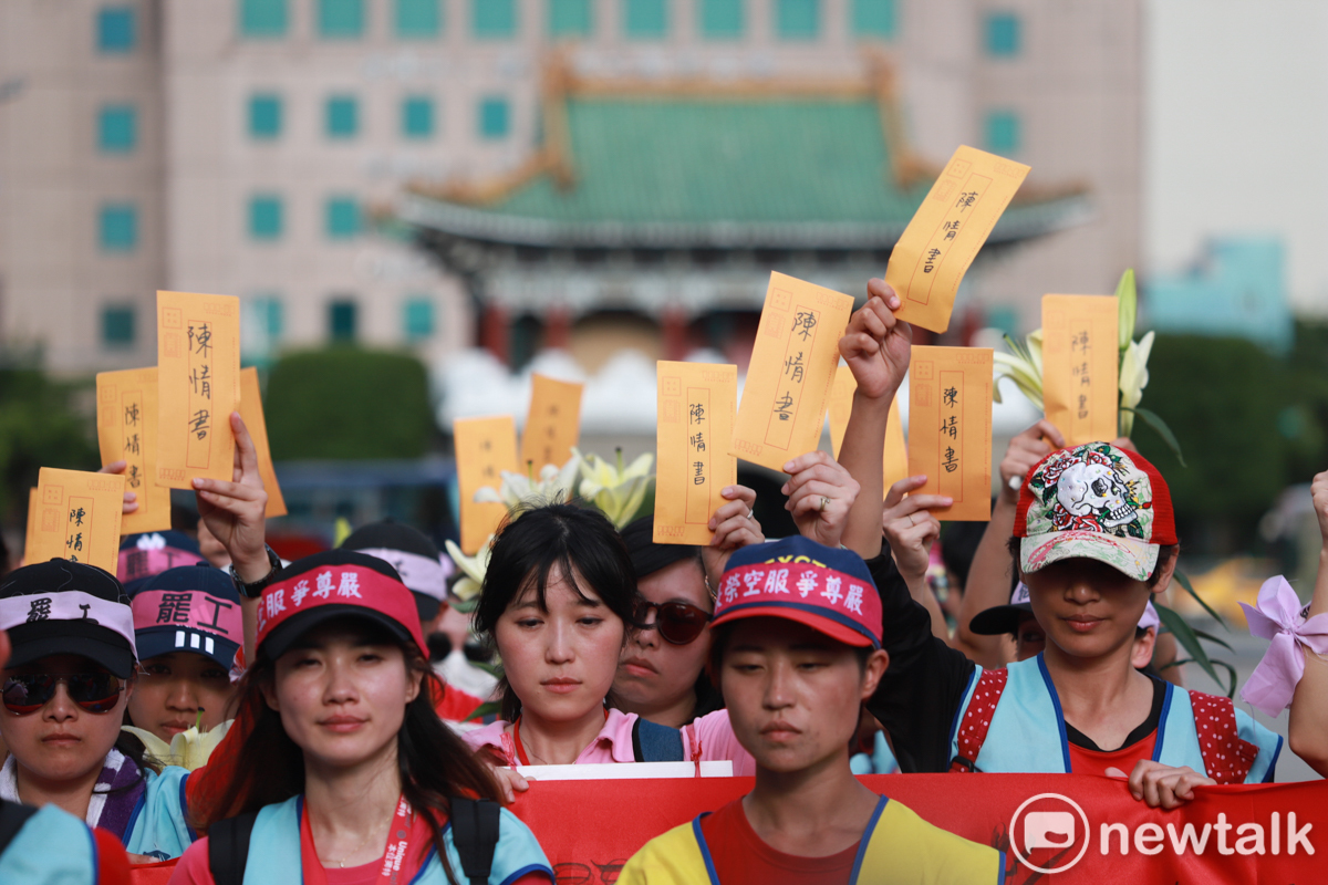 會員們高舉一人一封陳情書，由代表收集遞交給總統。 圖：謝佳真／攝