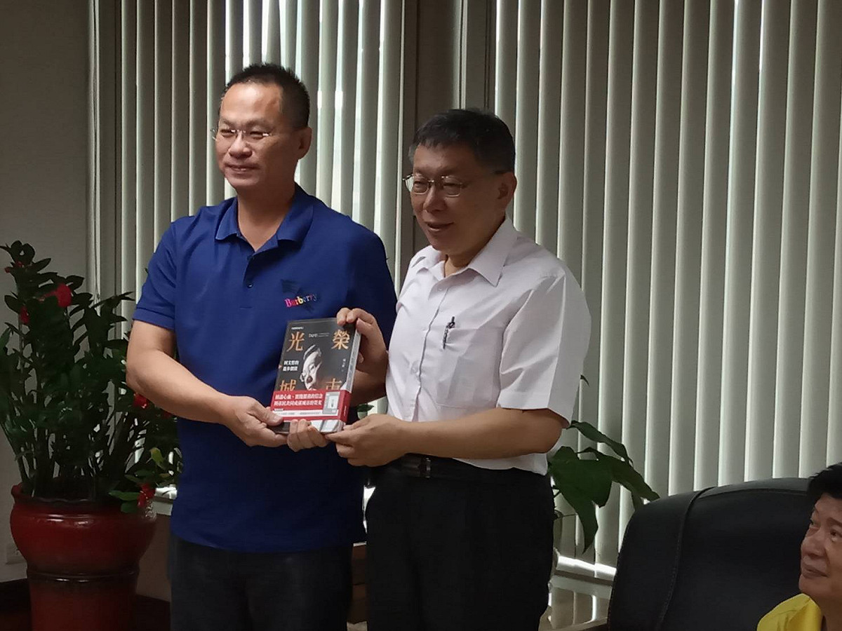 柯文哲（右）贈書給高雄水利會會長呂文豪。 圖：孫家銘／攝