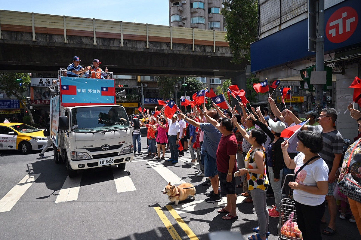 郭台銘今早在台北市街頭車隊掃街拜票，支持群眾在路邊揮舞國旗力挺。 圖：郭台銘競選辦公室／提供