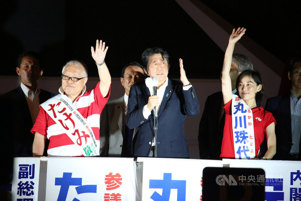 日本21日舉行參議院選舉投開票，執政聯盟自民、公明黨可望維持逾改選過半數席次。日本首相安倍晉三（中）20日選前最後一夜在東京秋葉原拉票時，得知現場有上萬人，愉快地喊：「勇氣百倍！」 圖/中央社