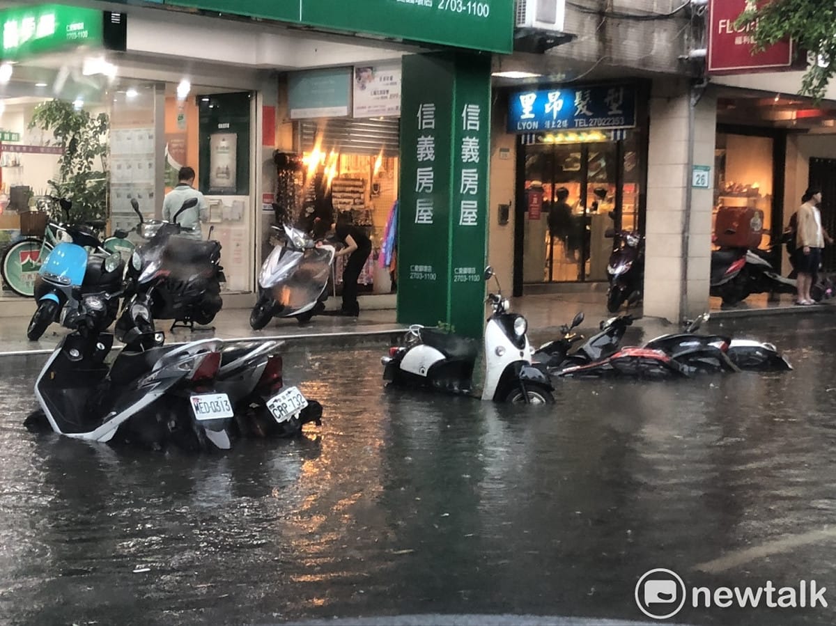 今（22）日中央氣象局針對台北市發布豪雨特報，台北市仁愛敦化路口已有機車泡水之情形。 圖：新頭殼/提供