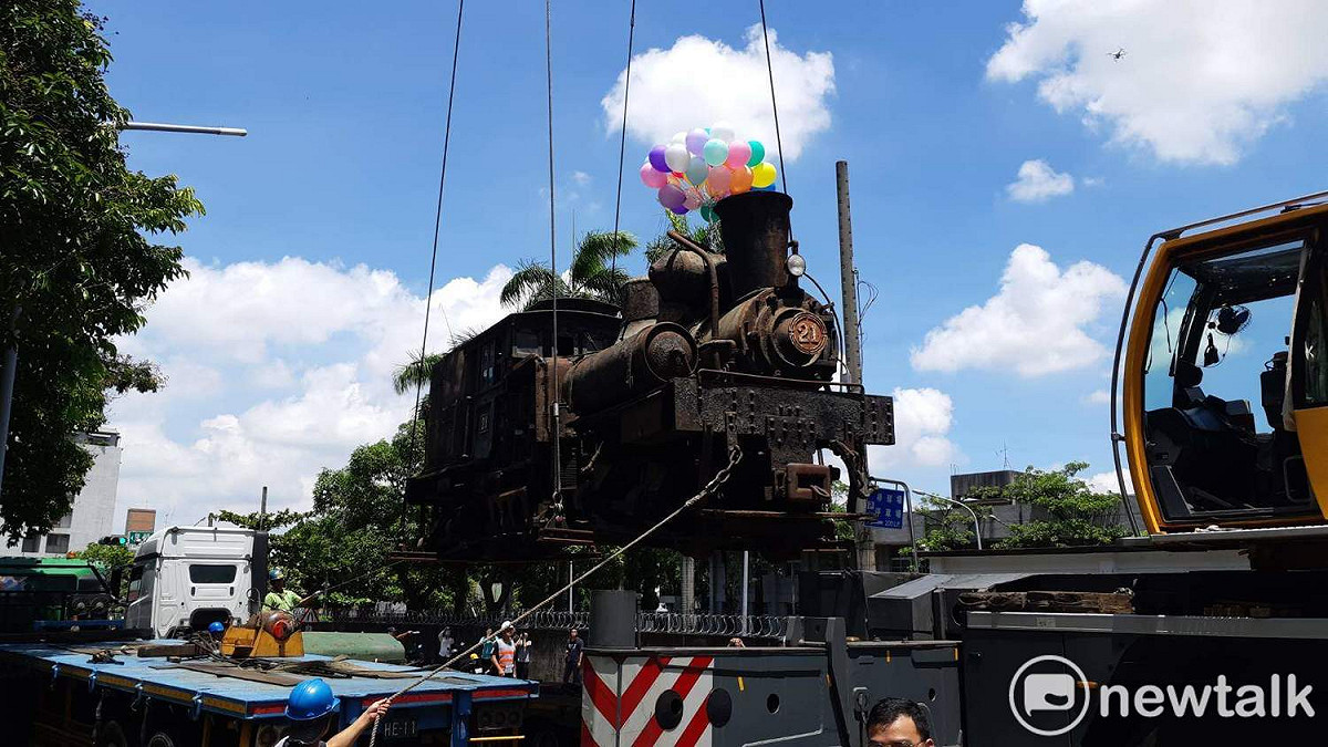工作人員將老火車頭吊上貨車，準備送往嘉義車庫園區維修。 圖：蔡坤龍/攝