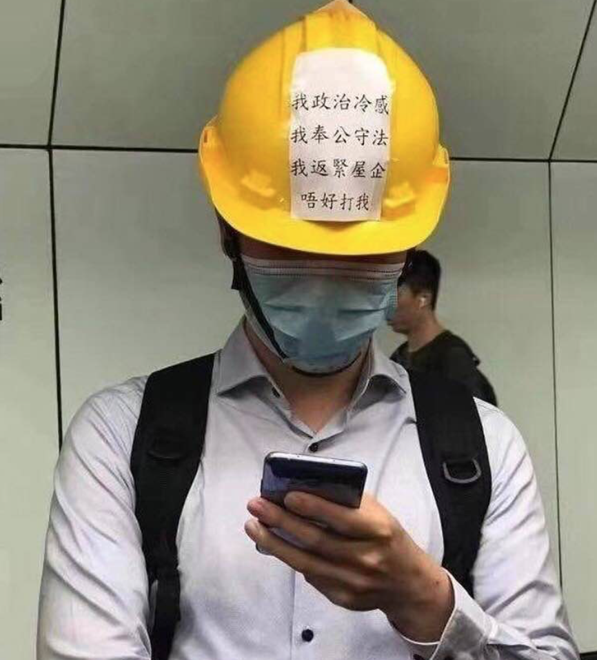 香港元朗爆發暴力事件後，網路上瘋傳港民上半族戴著頭盔上班，上面寫著「我政治冷感，我奉公守法，要趕快回家去，不要打我」。 圖：翻攝自陳芳明臉書