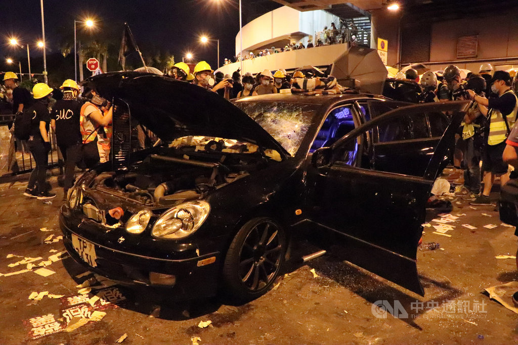 示威者在西鐵元朗站附近砸毀一輛汽車。據稱，示威者在車內發現藤條與一頂配有中共國徽的帽子，並在後車廂發現一把武士刀和數把木棍、鐵棍。 圖：中央社提供。