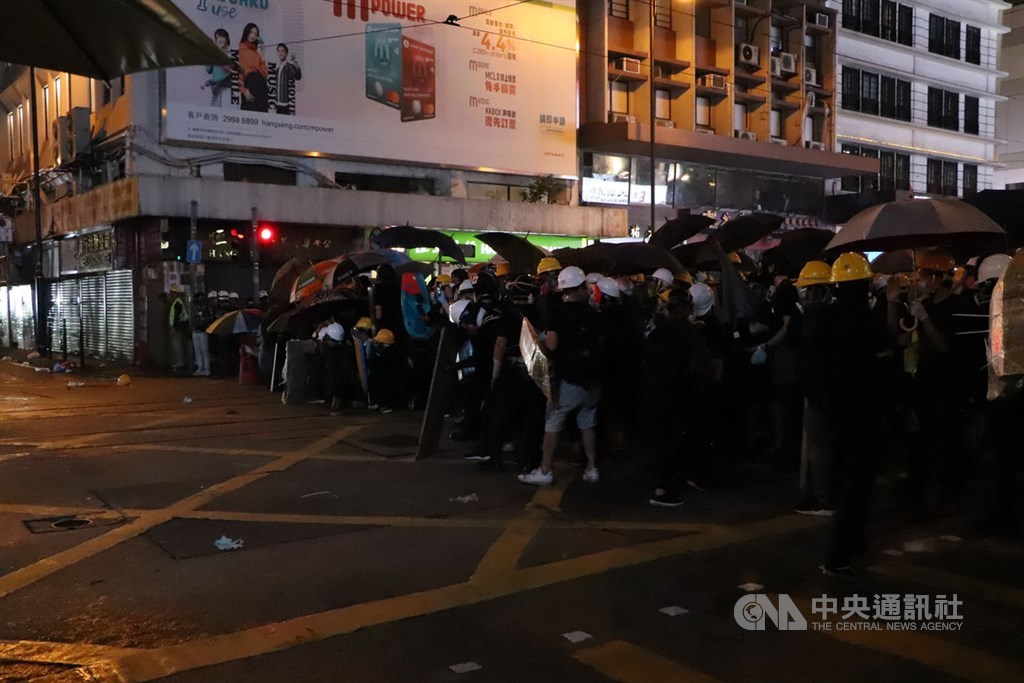 香港中環遮打花園追究警方用槍集會，演變為西環包圍中聯辦；港警晚間7時起清場，沿途狂射催淚彈意圖逼退示威者，有記者、示威者頭破血流，多人遭逮捕。圖為警方與示威者在上環一帶對峙。 圖：中央社提供。