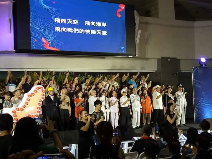 紀念會出現選舉造勢場合才有的百工百業大合唱。 圖：翻攝「Wecare高雄」臉書粉專