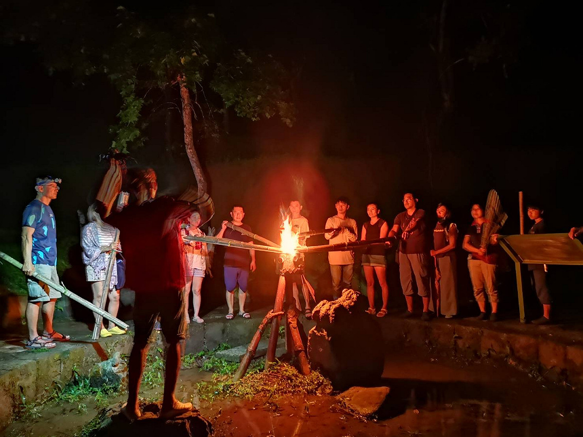 嘉義珈雅瑪青年壯遊點火祭體驗，在夜晚高舉火把，沿著溪水聲走向水火同源區。 圖：教育部／提供