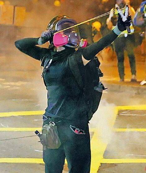 一個穿著黑色緊身衣、帶著防毒面具、拉緊彈弓對抗警察的女孩子，最近成了香港網路瘋傳的女主角。 圖 : 翻攝自桑普臉書