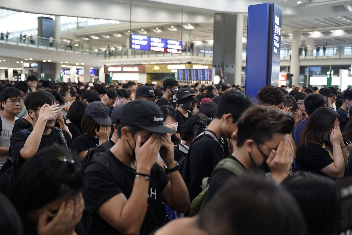 香港「反送中」機場集會，傍晚發起「靜默示威行動」， 現場數千名市民以黑布或手遮蓋口眼、靜默站立，抗議香港人被噤聲、打壓，以及一切政府無理行為。 圖：翻攝譚文豪 Jeremy Tam臉書