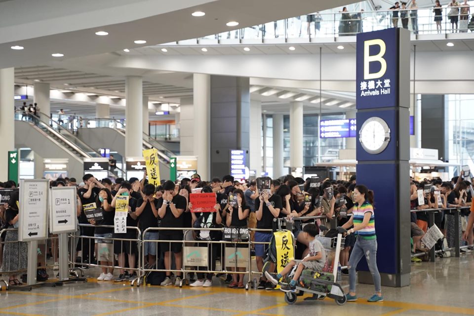 香港「反送中」機場集會，傍晚發起「靜默示威行動」， 現場數千名市民以黑布或手遮蓋口眼、靜默站立，抗議香港人被噤聲、打壓，以及一切政府無理行為。 圖：翻攝譚文豪 Jeremy Tam臉書