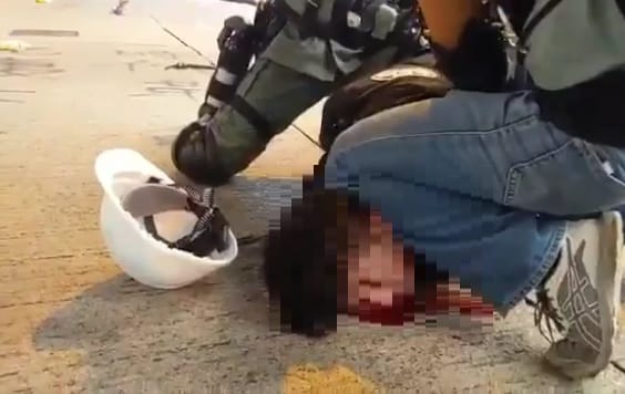 民眾遭港警攻擊，血流如注，惟港警仍將失血民眾強壓在地。 圖：翻攝自Alex Cheng 鄭思行臉書