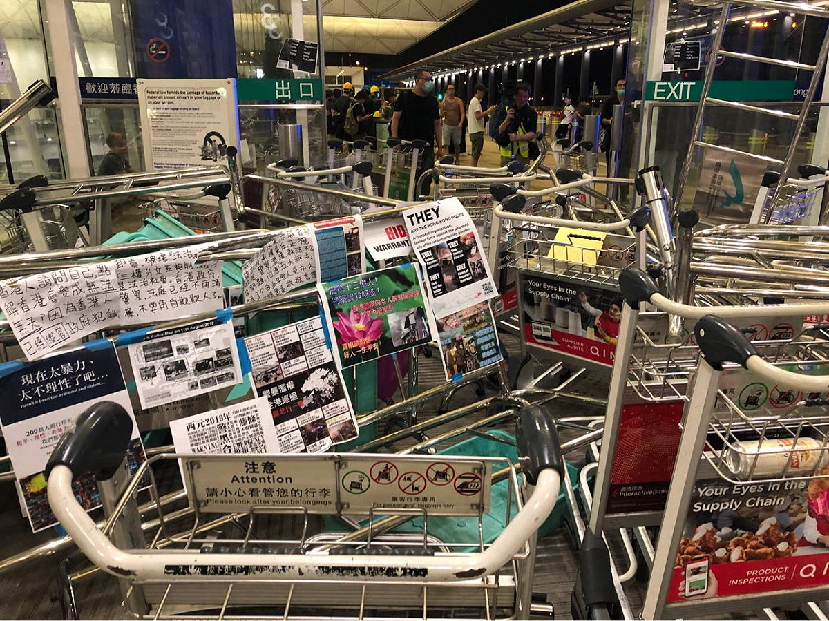 香港機場示威者以機場行李手推車雜亂堆停出入口，用以阻擋警方突襲。 圖：翻攝PTT網頁/taipei5566貼文
