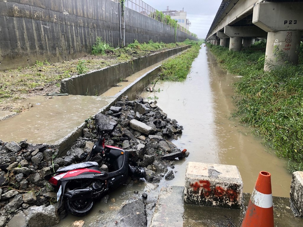 高雄13日豪雨未放假，林姓女子騎車上班行經岡山區一處水利局工程工地旁，現場工地開挖後疑未用鐵板鋪設路面，也未設護欄防護警示而釀意外。 圖 : 中央社