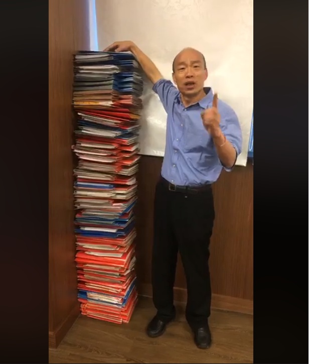 19日中午韓國瑜無預警開啟直播，主題是「勵志當全台灣最認真的市長」，以堆疊與韓幾乎等身高度的公文當背景，大嗆名嘴、蘇揆。 圖：翻攝韓國瑜臉書