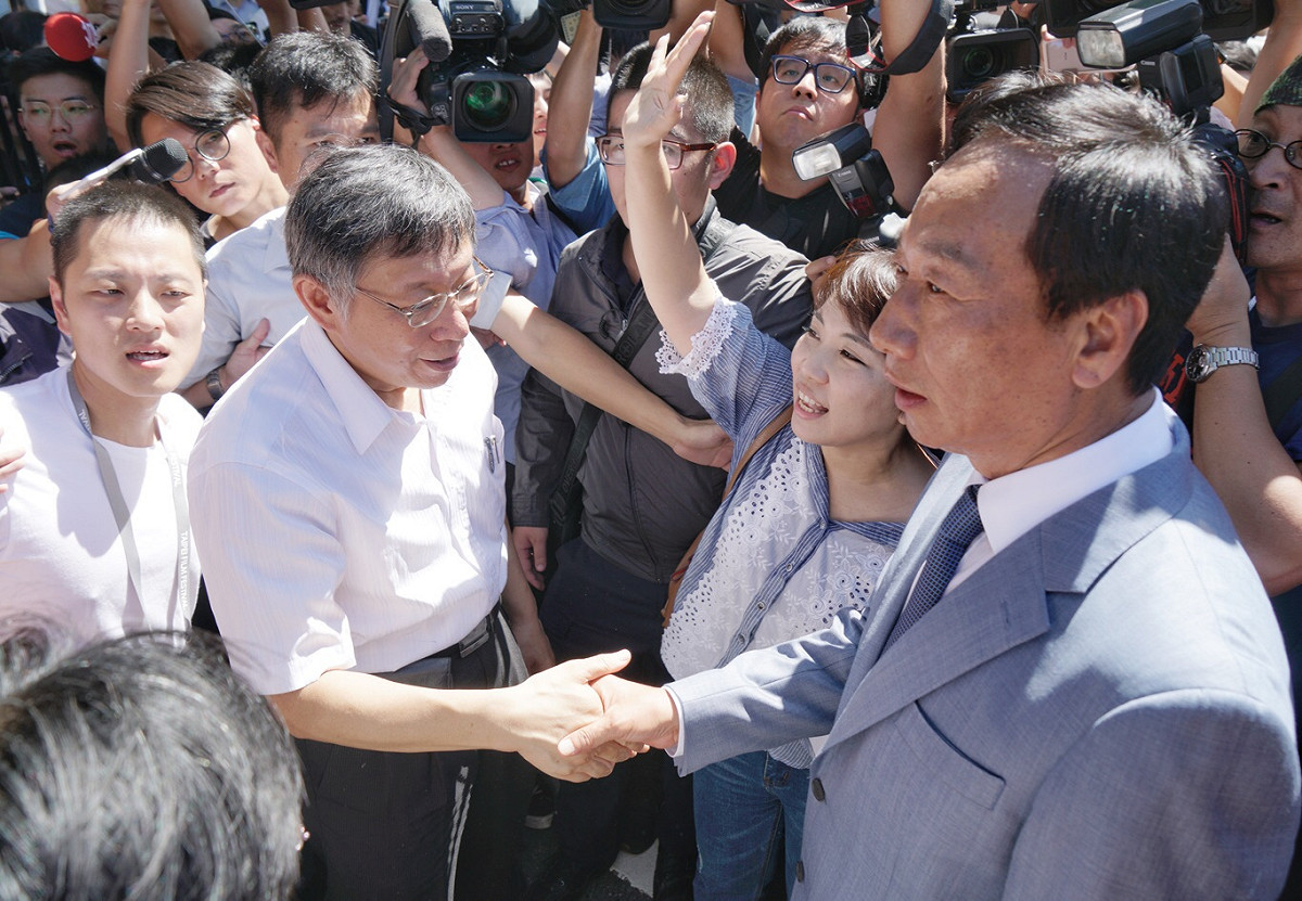 被人群團團包圍，柯文哲不忘與郭台銘握手。 圖：張良一/攝