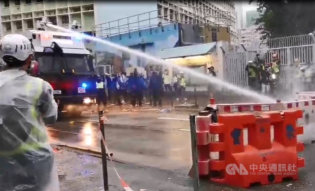 香港「反送中」支持者25日在新界荃灣舉辦荃葵青遊行，港警首度出動水槍車，朝示威者設置的障礙物噴水。 圖/中央社