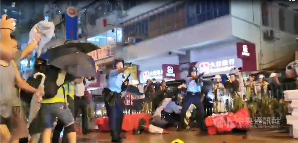香港「反送中」遊行今晚疑似首度出現警方發射實彈。入夜後，有約10名員警在抗爭現場遭示威者包圍追打，被圍員警拔出隨身的左輪手槍對空鳴槍示警，示威者一哄而散，並遭增援的員警追捕。 圖：中央社提供