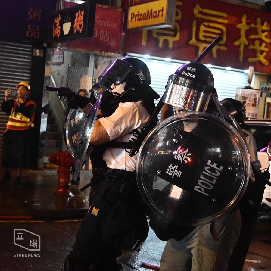 有香港警員拿槍對著人群和記者。 圖：擷取自立場新聞臉書。