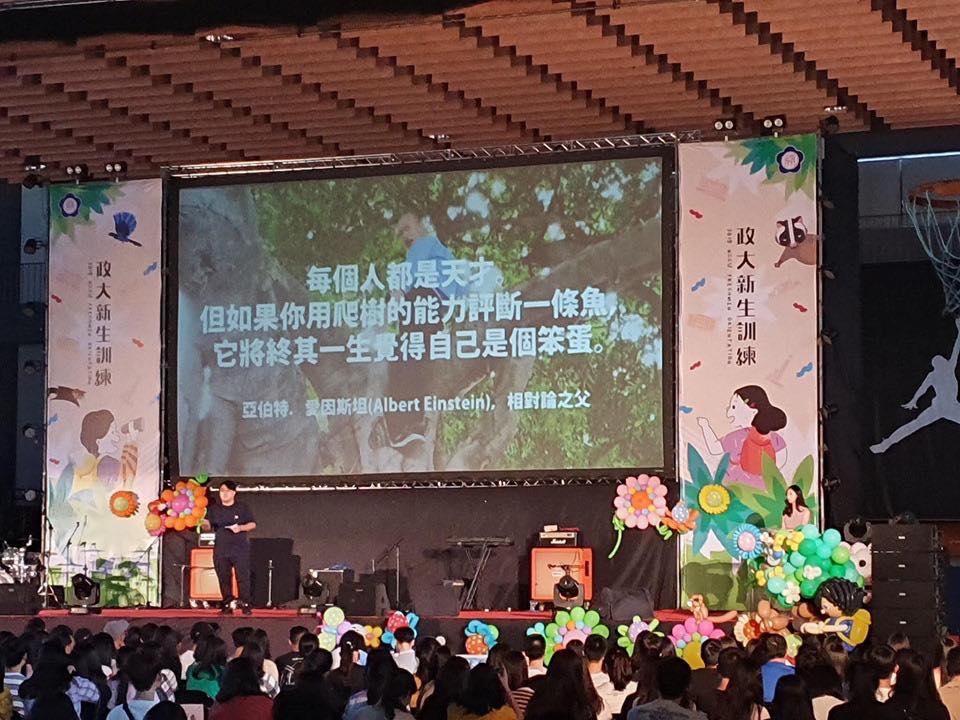 政大學生會長在新訓典禮引用名言「如果你用爬樹的能力評斷一條魚，牠將終其一生覺得自己是個笨蛋」，背景搭配韓國瑜爬樹照，引發兩極評論。 圖：翻攝自打馬悍將粉絲團