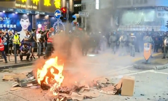 香港今（6）日晚間再度爆發警民衝突！示威者再度圍堵旺角警署，警方施放催淚彈驅離，群眾憤而縱火，目前仍持續對峙中。 圖：翻攝香港電台視像新聞畫面
