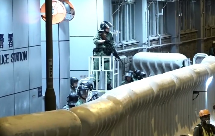 示威者再度圍堵旺角警署，警方持槍嚴陣以待。 圖：翻攝香港電台視像新聞畫面